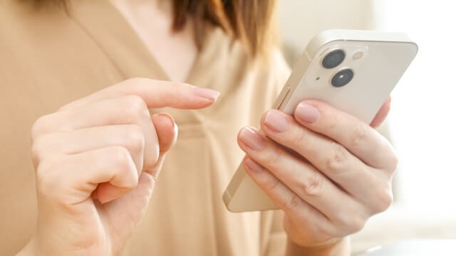 スマホを操作する女性の手元